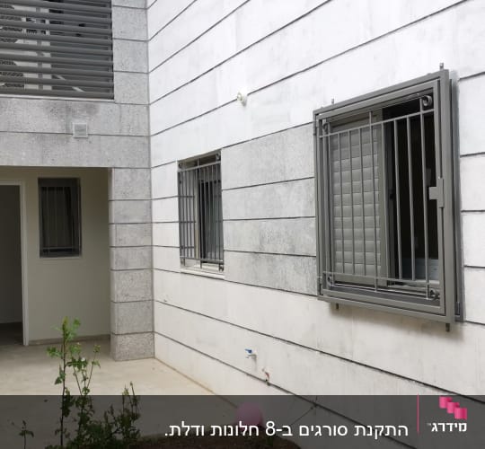 חלונות עם סורגים על קיר חיצוני של בניין